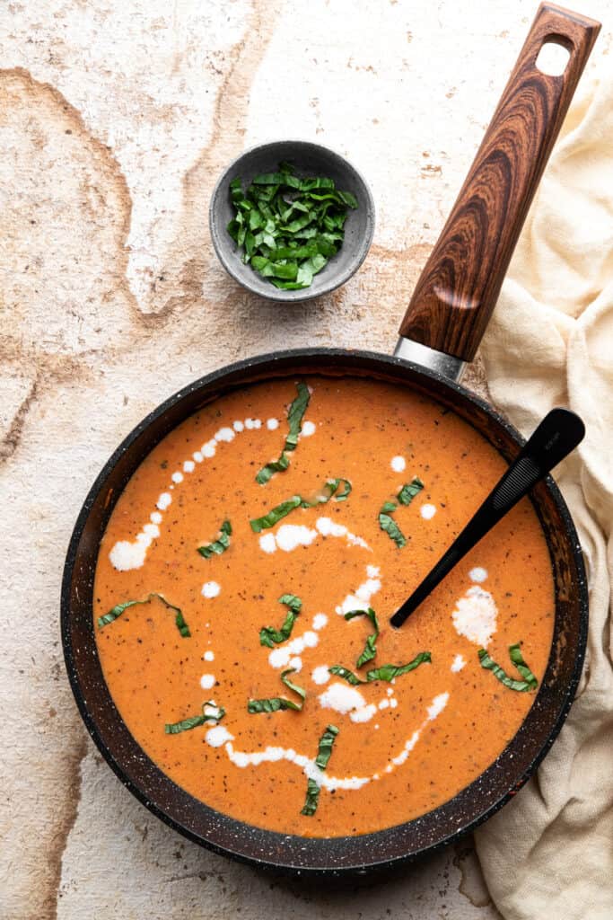 a pan filled with Keto Tomato Soup and a spoon