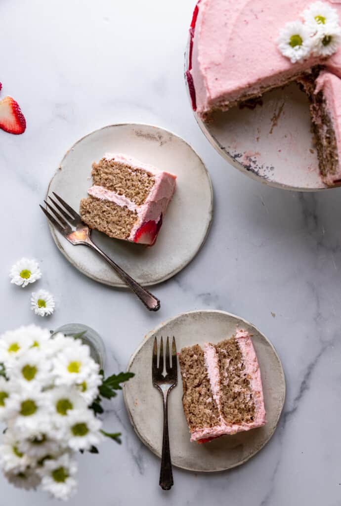 slices of Vegan Strawberry Cake on plates next to whole cake