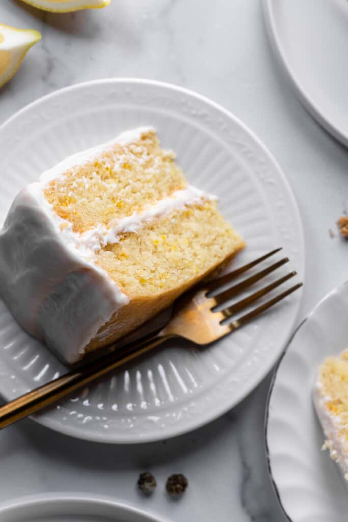 one slice of Vegan Lemon Cake on a small plate with a fork