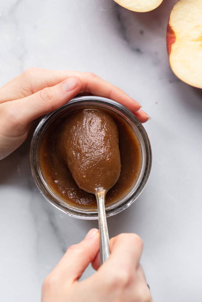 Slow Cooker Apple Butter being scooped out of a jar with a spoon